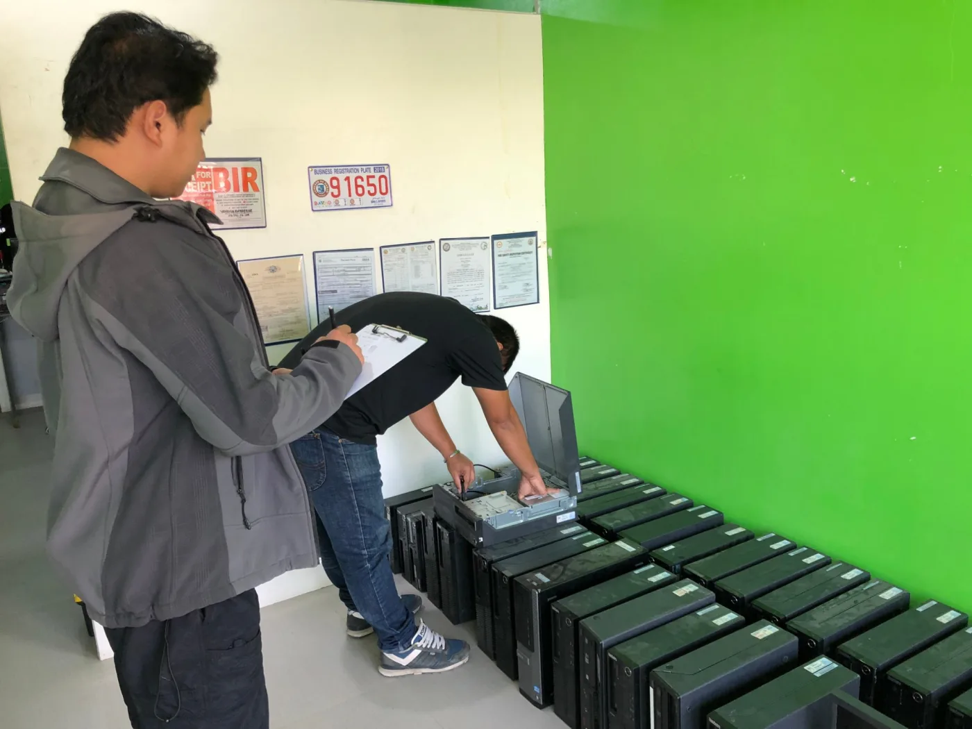 Ed Geronilla checking a row of refurbished computers at the Vendics Enterprise shop in Davao City